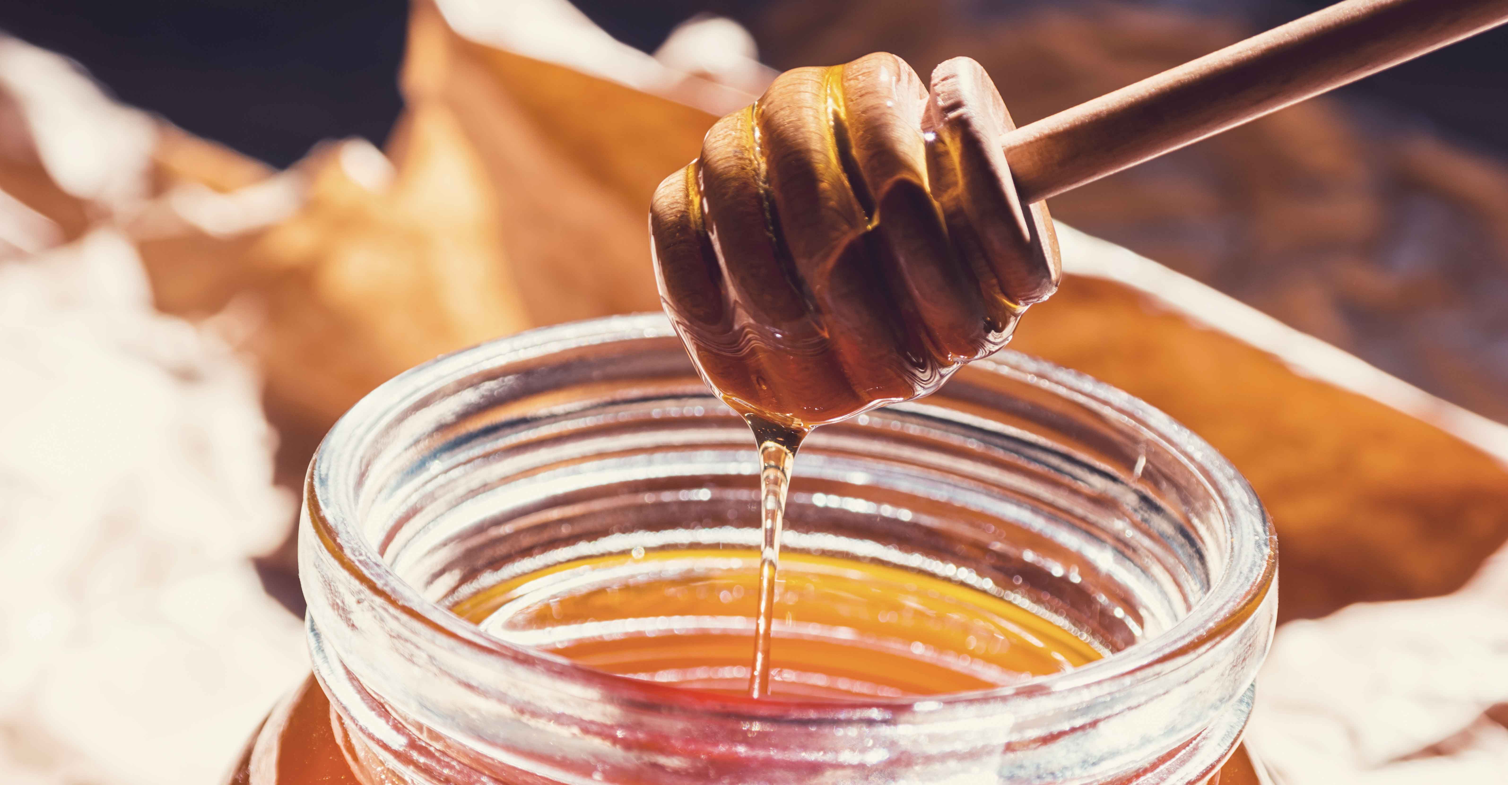 honey comb dipped in jar of honey