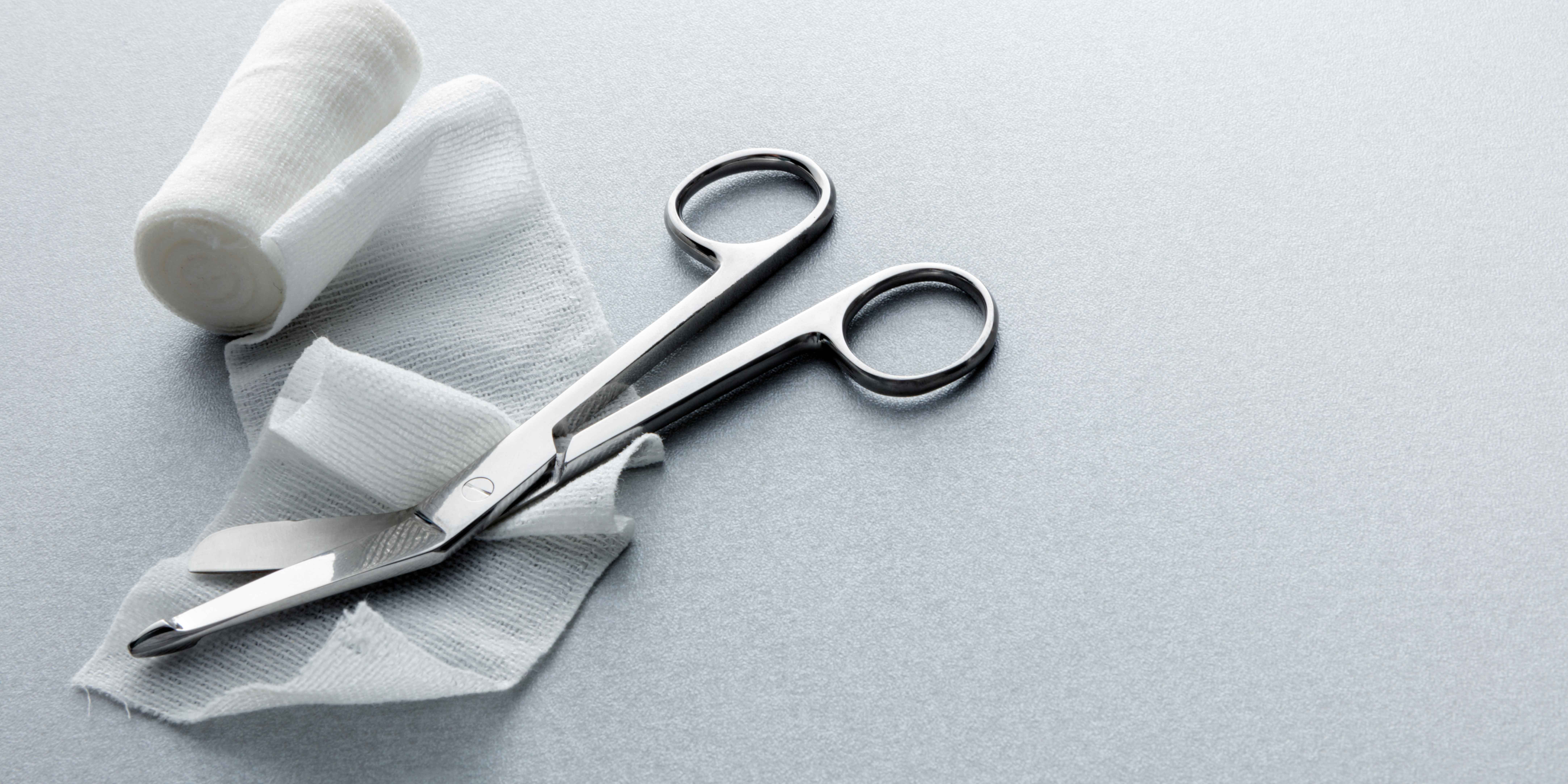 Gauze and surgical scissors sit on a desk.