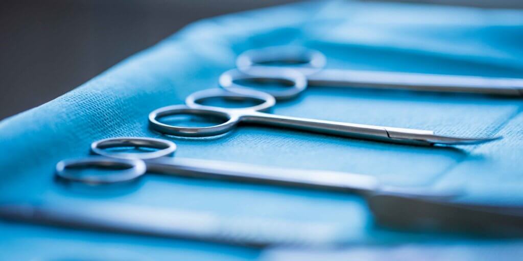 Tools to perform sharp debridement rest on a surgical tray.