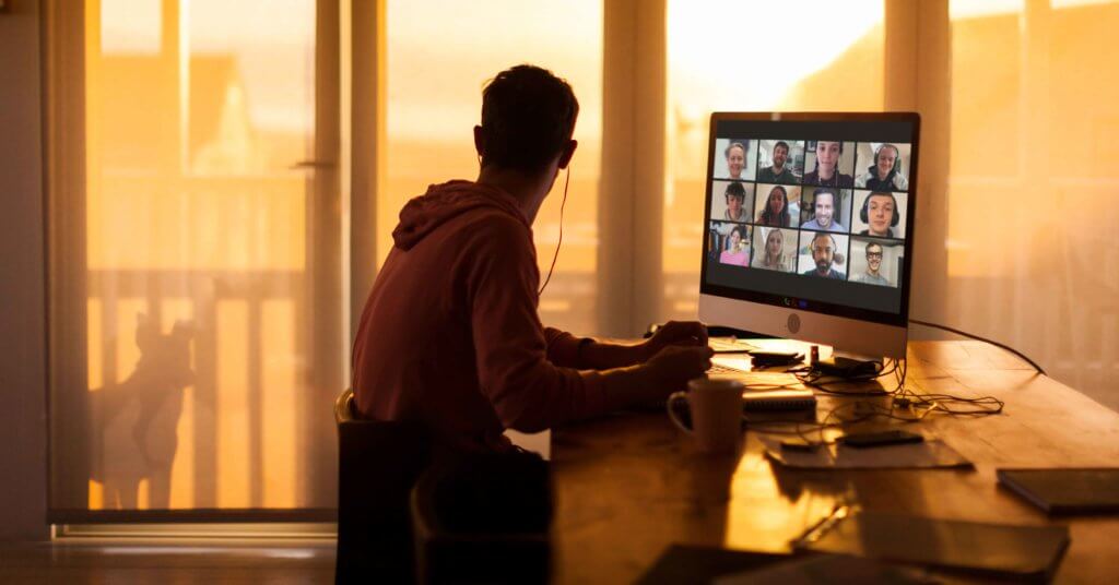 A man logs onto his live online training course at his desk.