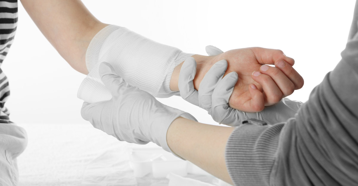 caregiver dresses patient's arm wound