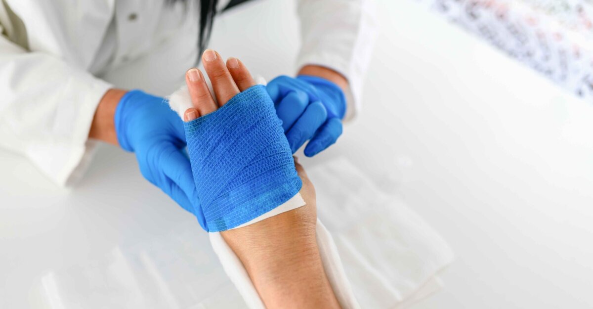 Healthcare professional dressing a wound on the hand
