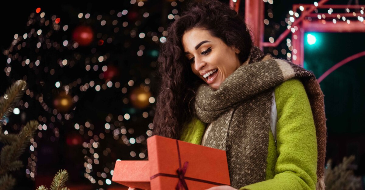 Woman opening presents with holiday discounts